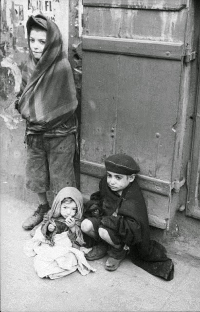 Três crianças judias, famintas e com frio no gueto de Varsóvia, durante a Segunda Guerra Mundial.