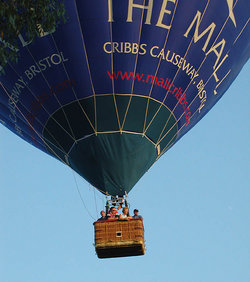 Um balão de ar quente sobre Bristol, Inglaterra, mostrando a cesta de vime passageiro.  Este balão carrega anunciando para um centro comercial.