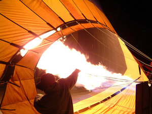 Um balão de ar quente é inflado por um banco de tochas de propano, pouco antes do amanhecer.